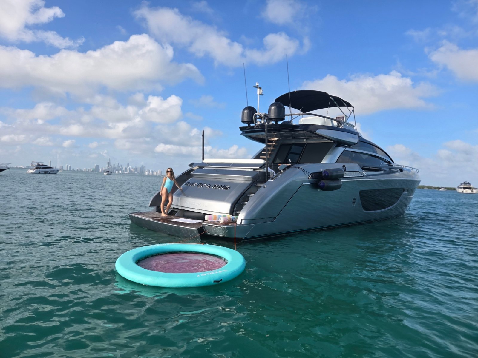 Yate fondeado en aguas turquesa con flotador y skyline de Miami